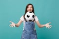 Surprised funny young woman football fan cheer up support favorite team throwing soccer ball isolated on blue turquoise