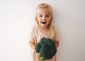 Surprised girl with broccoli healthy food vegan child family lifestyle organic vegetables harvest Royalty Free Stock Photo