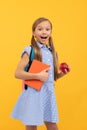 Surprised girl child hold tasty apple for healthy back to school snack, school fruit Royalty Free Stock Photo