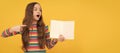 Surprised girl child point finger at open book for copy space yellow background, pointing. Banner of schoolgirl student Royalty Free Stock Photo