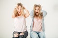 Surprised girl looking at her sister twin over white background