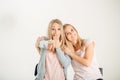 Surprised girl looking at her sister twin over white background