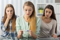 Surprised girl looking at pregnancy test with girlfriends