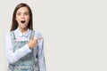 Surprised girl pointing finger aside at copyspace studio gray background Royalty Free Stock Photo