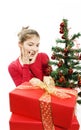 Surprised girl with presents near a christmas tree Royalty Free Stock Photo