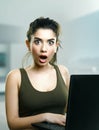 Surprised girl shocked by laptop media news