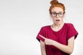 Surprised girl showing empty copy space with her finger white background Royalty Free Stock Photo