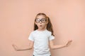 Surprised girl 7 years old in round glasses against the pink background with 2 empty spaces Royalty Free Stock Photo