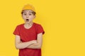 Surprised guy in hardhat on yellow background. Choice of future profession. Copy space