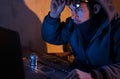 Surprised hacker looks at the laptop, the intruder breaks into a system,