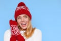 Surprised happy beautiful woman looking sideways in excitement. Christmas girl wearing knitted warm hat and mittens, on b