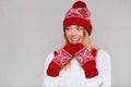 Surprised happy beautiful woman looking sideways in excitement. Christmas girl wearing knitted warm hat and mittens, isolated on Royalty Free Stock Photo