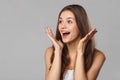 Surprised happy beautiful woman looking sideways in excitement. Isolated on gray background Royalty Free Stock Photo