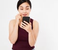 Surprised happy korean woman looking at mobile phone isolated on white background Royalty Free Stock Photo