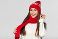 Surprised happy woman in excitement. Christmas girl wearing knitted warm hat and scarf, isolated on gray background Royalty Free Stock Photo