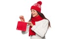 Surprised happy woman holding and looks in red bag in excitement, shopping. Christmas girl on winter sale with gift, isolated Royalty Free Stock Photo