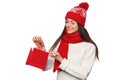 Surprised happy woman holding and looks in red bag in excitement, shopping. Christmas girl on winter sale with gift, isolated Royalty Free Stock Photo