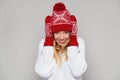 Surprised happy woman looking sideways in excitement. Christmas girl wearing knitted warm hat and mittens, isolated on gray backgr Royalty Free Stock Photo