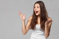 Surprised happy woman looking sideways in excitement, isolated on gray background