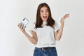 Surprised and happy woman winning in video game on smartphone, looking amazed at camera, standing in t-shirt against Royalty Free Stock Photo