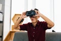 Surprised hipster playing video games using VR goggles