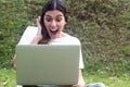 Surprised Hispanic woman using laptop in outdoors