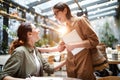 Surprised lady bumping into friend in cafe