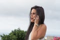 Surprised latina with dark hair listening a friend in the cell phone with open mouth and shocked. Long hair woman excited calling Royalty Free Stock Photo