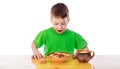 Surprised little boy eating oatmeal at the table Royalty Free Stock Photo