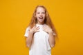 Surprised little ginger kid girl 12-13 years old in white t-shirt isolated on yellow wall background children studio Royalty Free Stock Photo