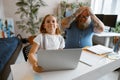 Surprised little girl does homework on laptop while father clutches head at home