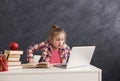 Surprised little girl doing homework on laptop Royalty Free Stock Photo