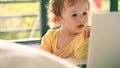 Surprised little girl looks at the laptop screen Royalty Free Stock Photo