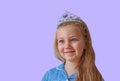 Beautiful little princess girl in sparkling silver crown.Emotional young lady with long wavy hair in blue dress portrait Royalty Free Stock Photo