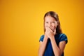 Surprised Little Redhead Girl Smiling And Covering Mouth Royalty Free Stock Photo