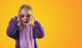 surprised little toddler girl in pajamas hands on her head yellow background Royalty Free Stock Photo