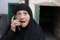 Surprised looking senior Islamic woman getting a phone call Royalty Free Stock Photo