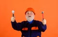 Surprised male builder in protective hard hat with adjustable wrench and hammer. Mechanical worker or repairman in Royalty Free Stock Photo