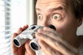 Surprised man with binoculars. Curious guy with big eyes. Nosy neighbour stalking or snooping secrets, gossip and rumour. Royalty Free Stock Photo