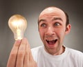 Surprised man holding lighting bulb
