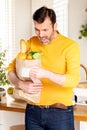 Surprised man looking at store receipt after shopping, holding a paper bag with healthy food. Guy in the kitchen