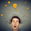 Surprised man with many ideas light bulbs above head looking up Royalty Free Stock Photo