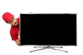 Surprised man in red uniform looking at big blank tv screen Royalty Free Stock Photo