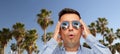 Surprised man in sunglasses over palm trees Royalty Free Stock Photo