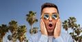 Surprised man in sunglasses over palm trees Royalty Free Stock Photo