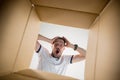 Man unpacking and opening carton box and looking inside Royalty Free Stock Photo