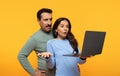 Surprised man and woman in casual attire react to shocking news on a laptop screen with incredulous expressions Royalty Free Stock Photo