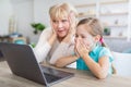 Surprised mature woman and granddaughter using laptop Royalty Free Stock Photo