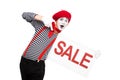 surprised mime pointing on sale signboard