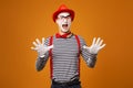 Surprised mime in red hat and striped t-shirt on blank orange background Royalty Free Stock Photo